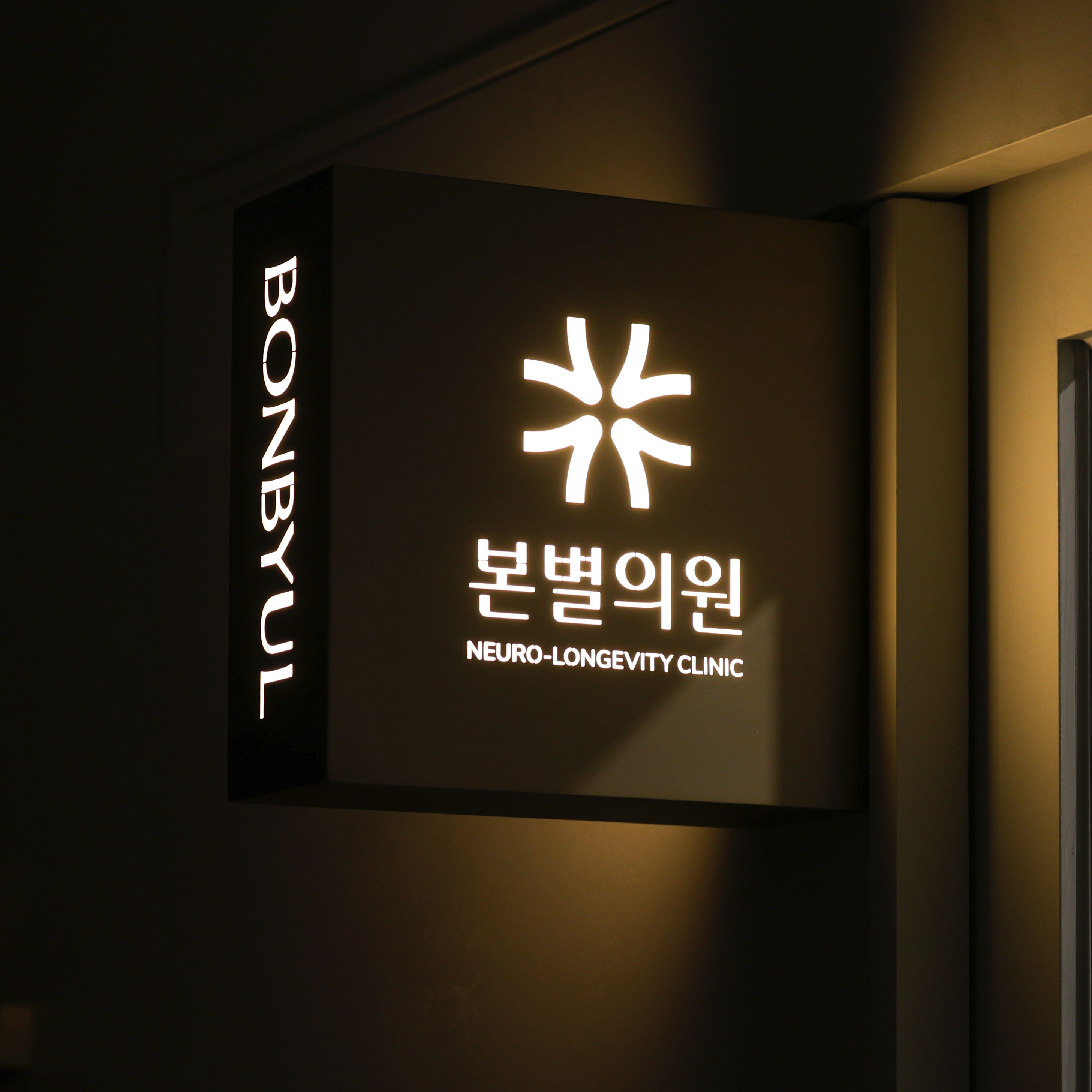 따뜻한 조명으로 빛나는 본별의원 간판 — NEURO-LONGEVITY CLINIC